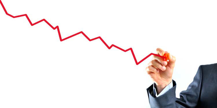 Businessman is drawing a graph with red line going down