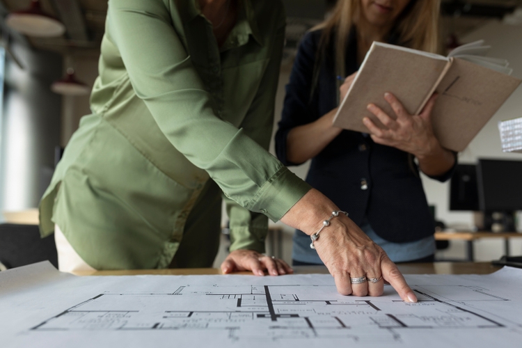 Close Up Of Architects Analyzing Floor Plans While Designing Building Together