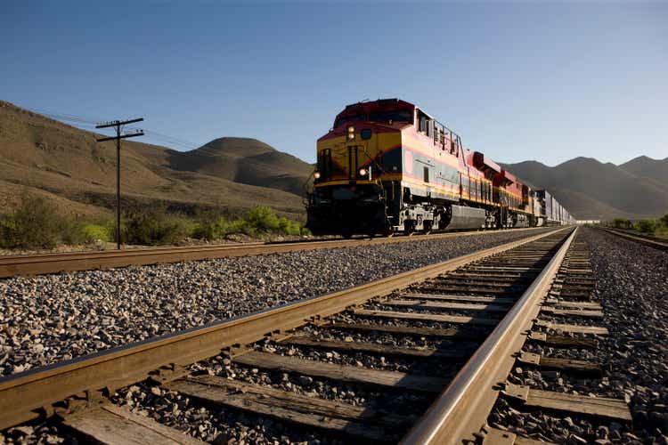 Angled view of train tracks with oncoming freight train