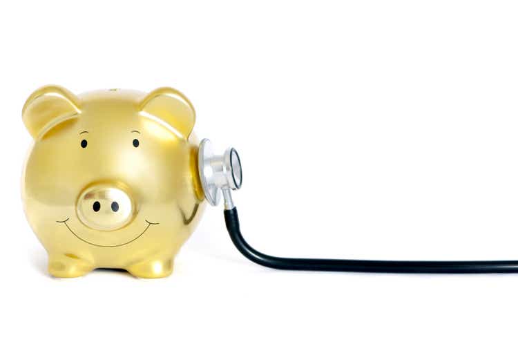 Yellow piggy bank with stethoscope on his side