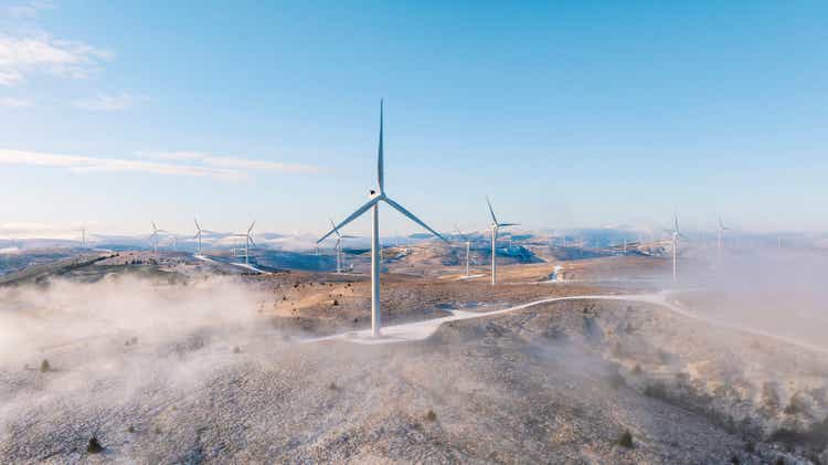 A drone/aerial view of a wind farm on a hilltop in Scotland on a frosty winter"s morning