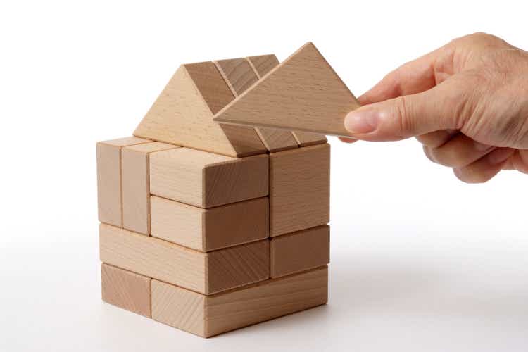 A house made of wooden blocks, hand-made, on a white background.