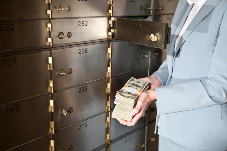 Woman putting cash in safety deposit box