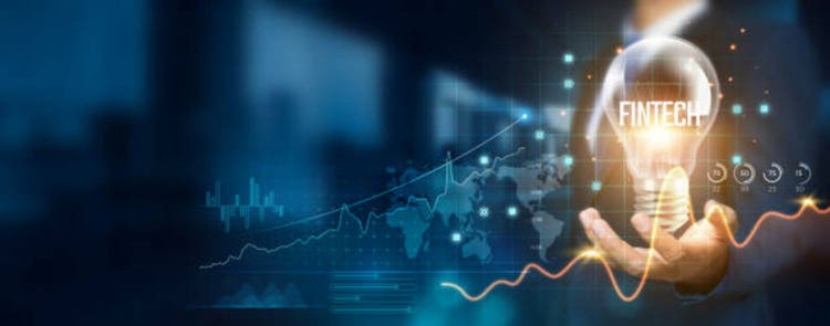 Businessman holding creative light bulb with growth graph and financial technology icons. Fintech innovation technology develops new solutions and strategies that enhance successful and profit.