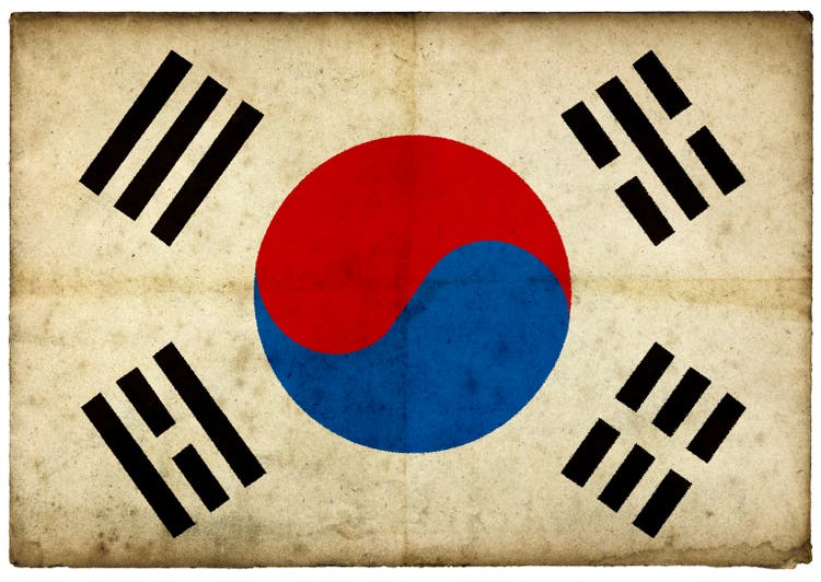 Grunge South Korean Flag on rough edged old postcard