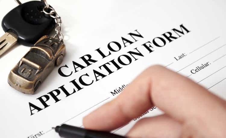 An empty car loan form with car key and a pen