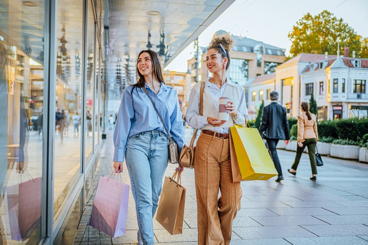 Female friends looking at store window