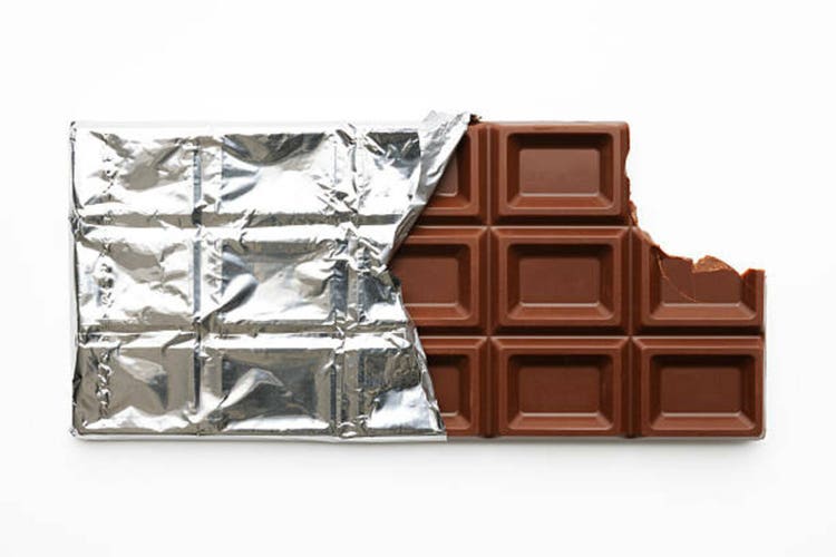 Chocolate bar with a missing bite on white background