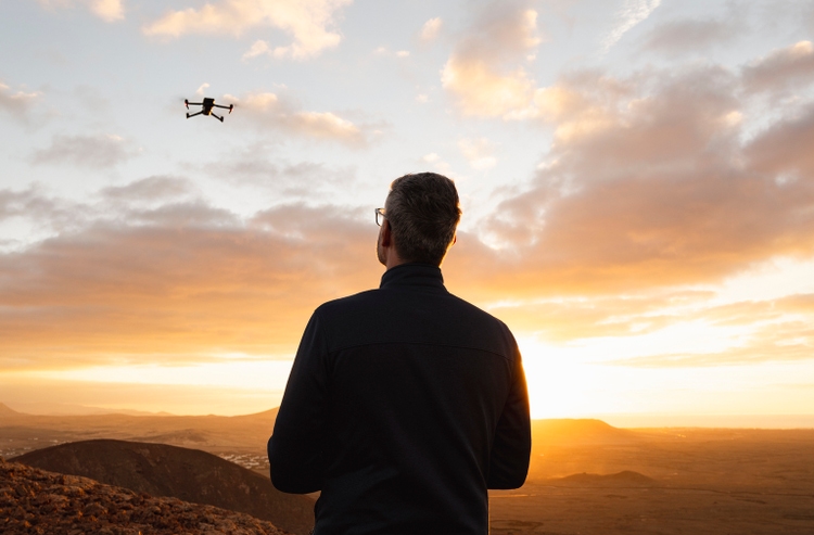 Mature man flying a drone in a rugged landscape