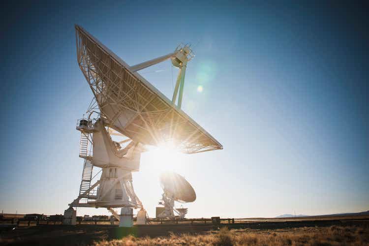 Sun shining behind satellite dish in desert, Socorro, New Mexico, United States