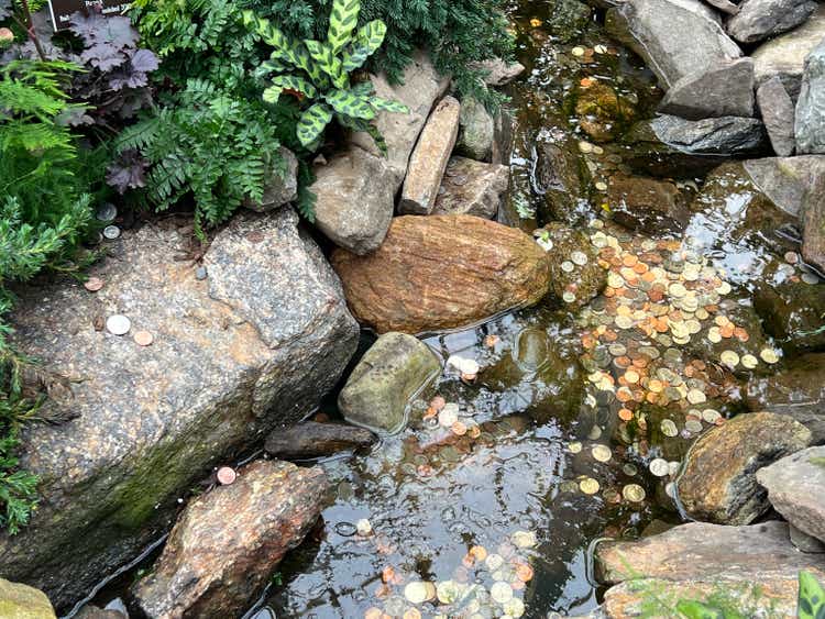 A waterfall and brook in a tropical garden with coins in the rocky bottom