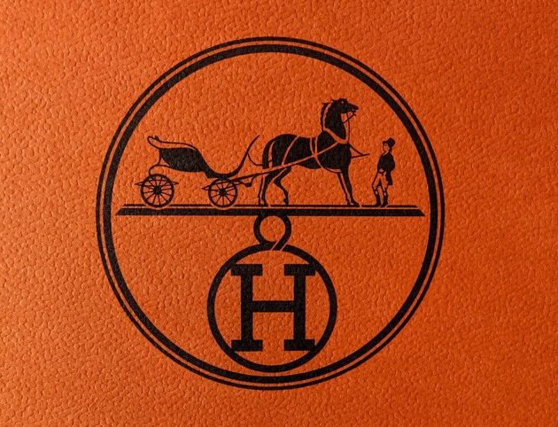 Stylish background of orange leather with the Hermes logo