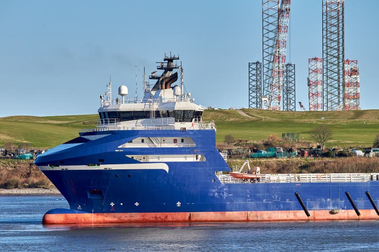Supply vessel navigating in port.