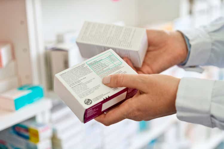 Female pharmacist holding medicines, close up of hands