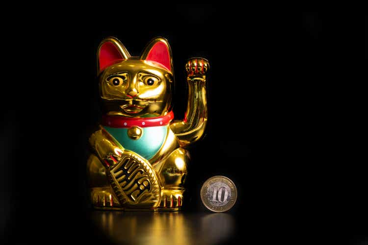 Chinese commemorative cat statue and 10 yuan coin symbolizing wealth