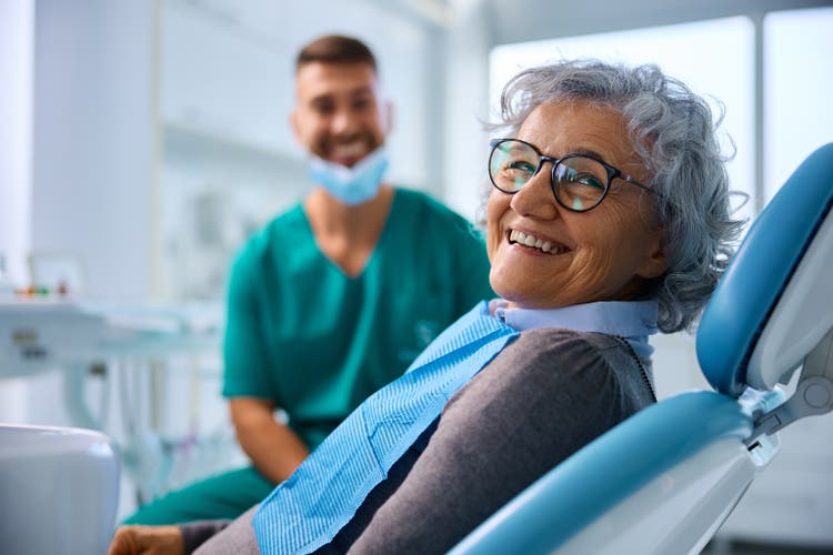 Satisfied senior woman at dentist"s office looking at camera.
