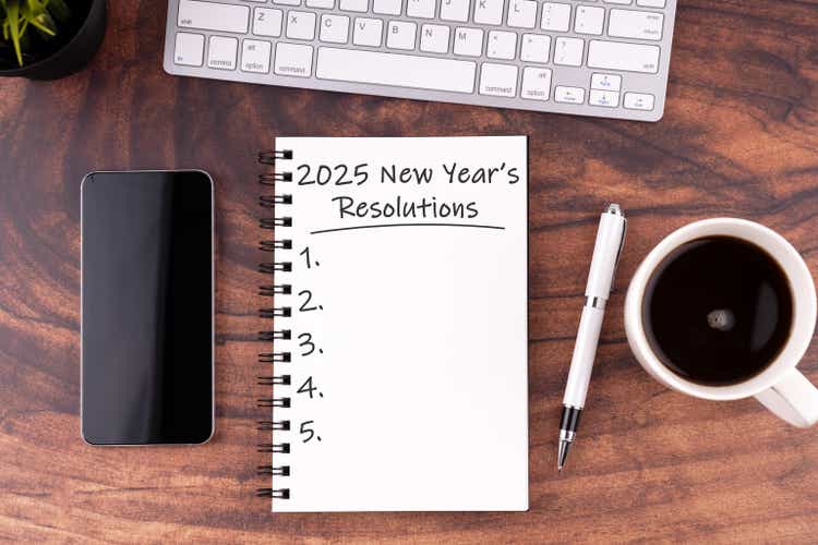 New Year"s Resolutions 2025 text on note pad stock photo on wood desk