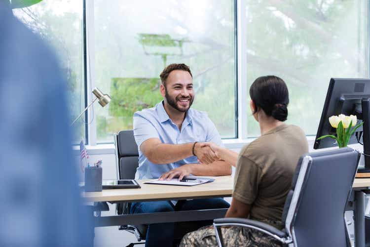 Mid adult male job recruiter meets with the female soldier