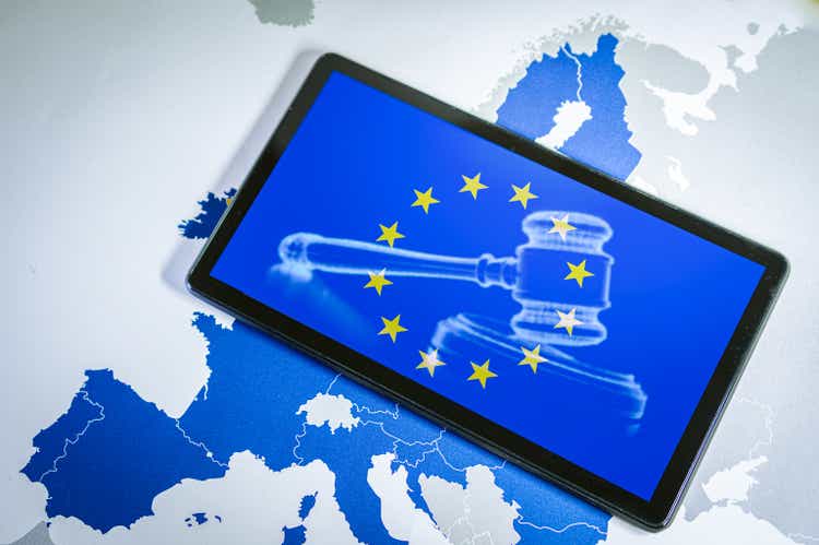 EU Flag with gavel and sound block on smartphone screen over a Eu map.