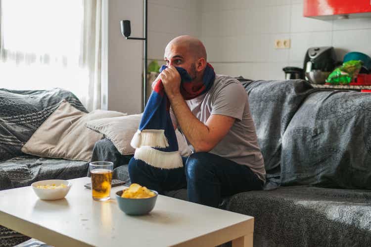 Man suffering watching sports on the sofa