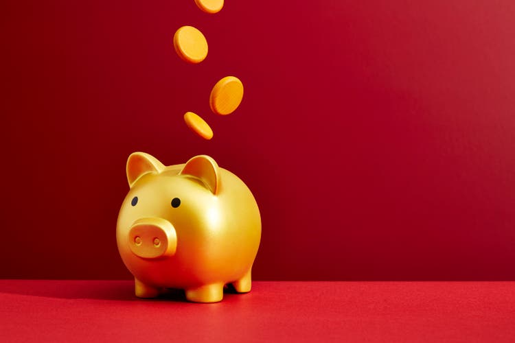 Coins dropping into a piggy bank