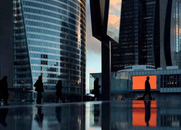 Afternoon commute with people passing by at pedestrian zone of modern business district