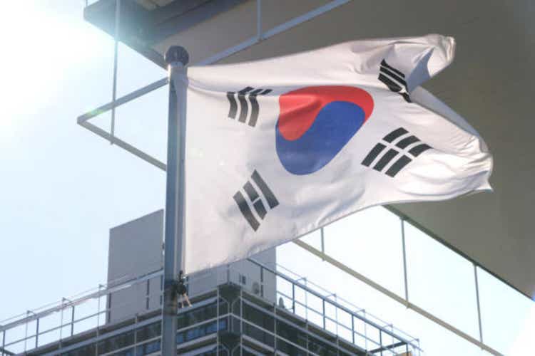 against background of multi-storey silk national flag of modern state of Republic of Korea, flutters silk cloth against sky, for designer, independence day, development of state