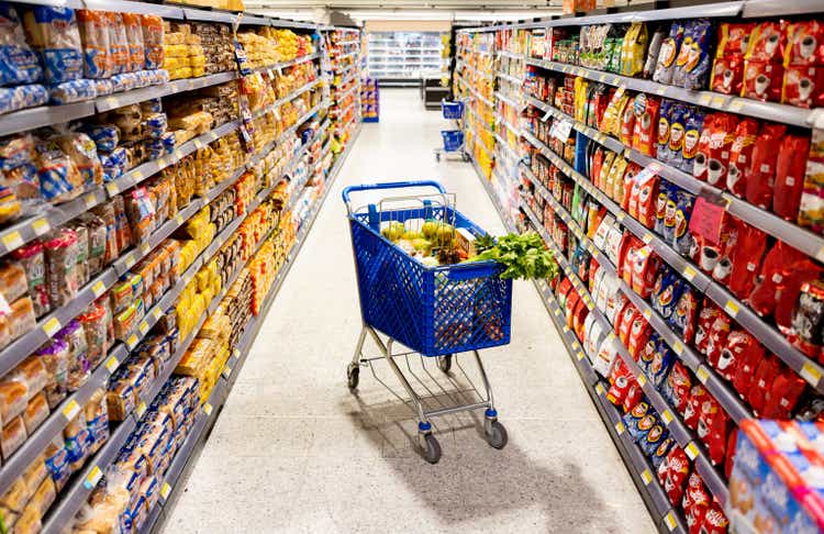 Shopping cart in the middle on an aisle at the supermarket