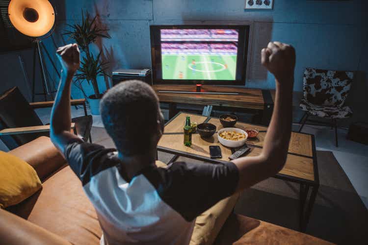 Young man watching soccer game at home