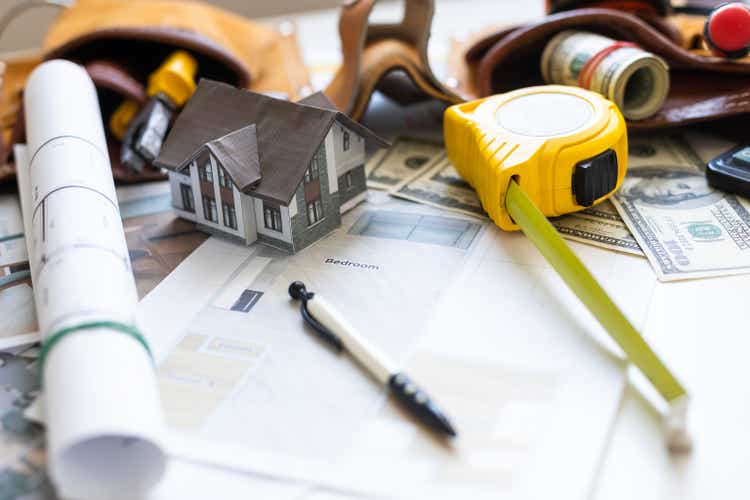 A model house on blueprints with keys to the new home Close up