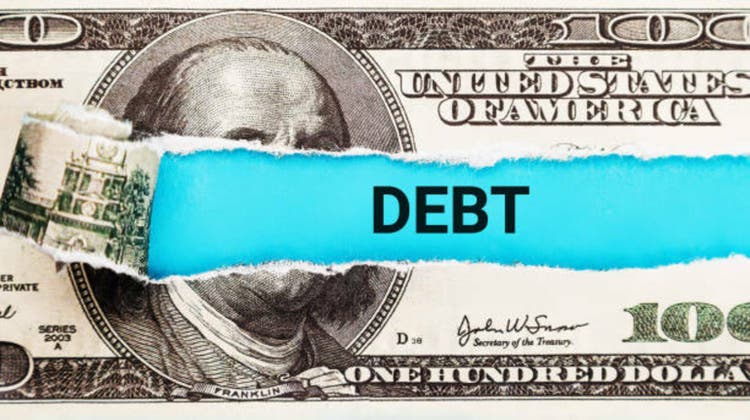 Debt. The word Debt in the background of the US dollar. Financial Burden, Loan, and Credit Concept. Stress from Financial Obligations