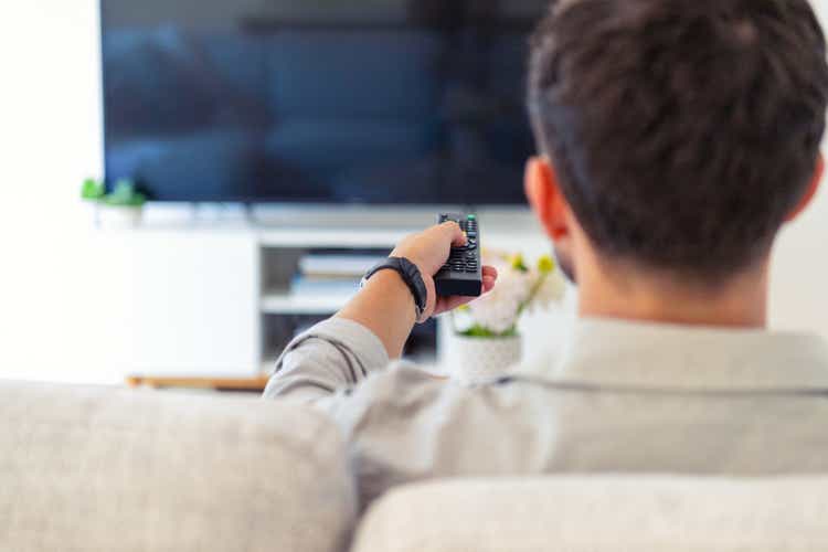 Man watching TV on the sofa during the day.