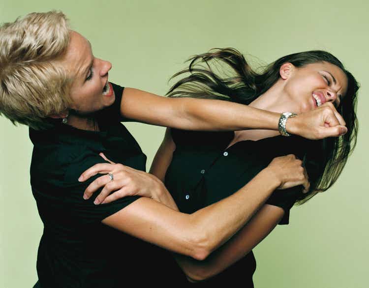 Mature businesswoman punching woman