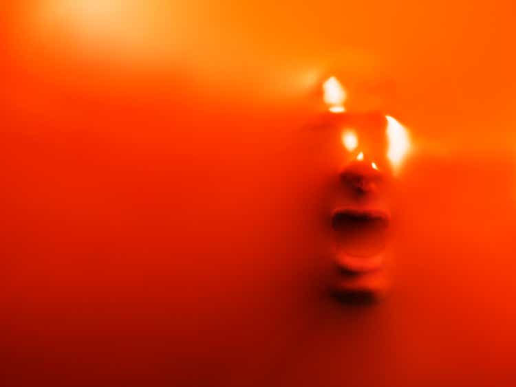 Impression of man"s face through orange rubber, close-up