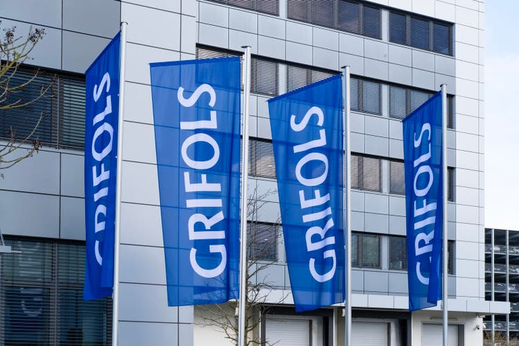 satin flags with letters GRIFOLS fluttering on silk cloth, global healthcare company develops plasma-derived medicines, innovative biopharmaceutical solutions, Frankfurt, Germany - February 13, 2024