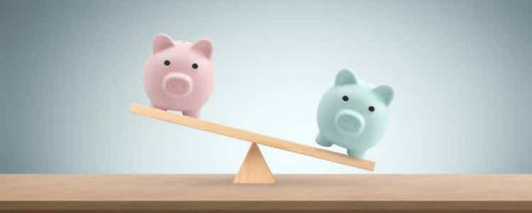 Piggy bank on balance scale Gender pay equality conceptt