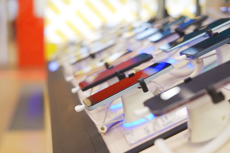 A lot of smartphone models on display at the exhibition stand of an electronics store