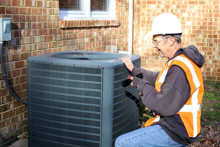 Home inspection of central air unit by a maintenance worker