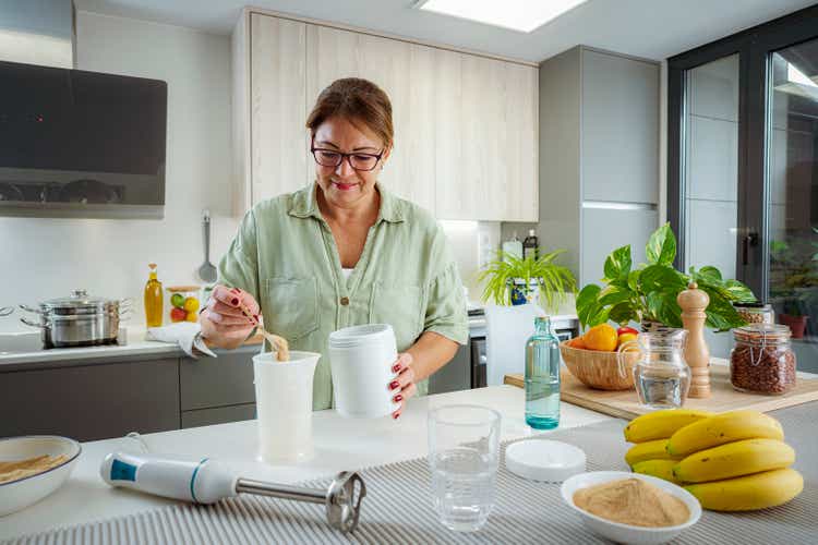 Mature woman preparing meal replacement shake