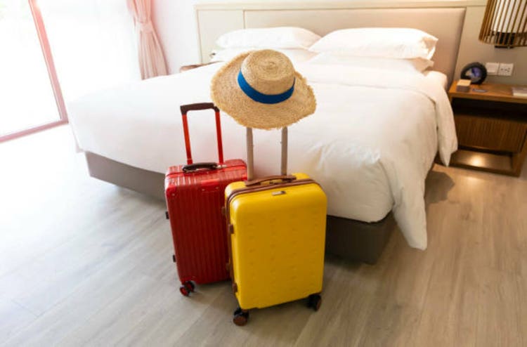 The travel with a colors luggage as business trip in a Holiday image of city building background, journey holiday concept