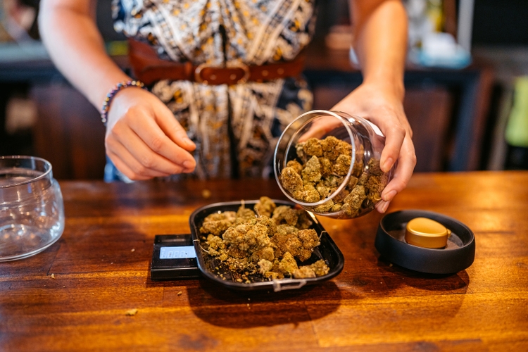 Young Woman Weighing Herbal Cannabis On A Scale In A Cannabis Shop In Thailand
