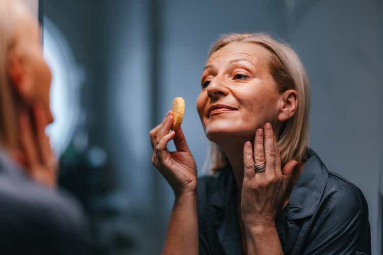 Portrait of a Beautiful Older Woman Using a Make up Sponge in the Bathroom