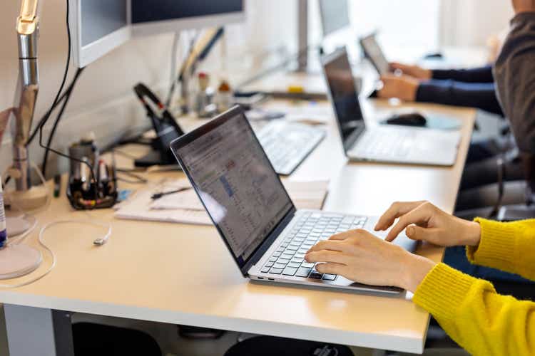 Close-up of woman typing on computer keyboard at workplace