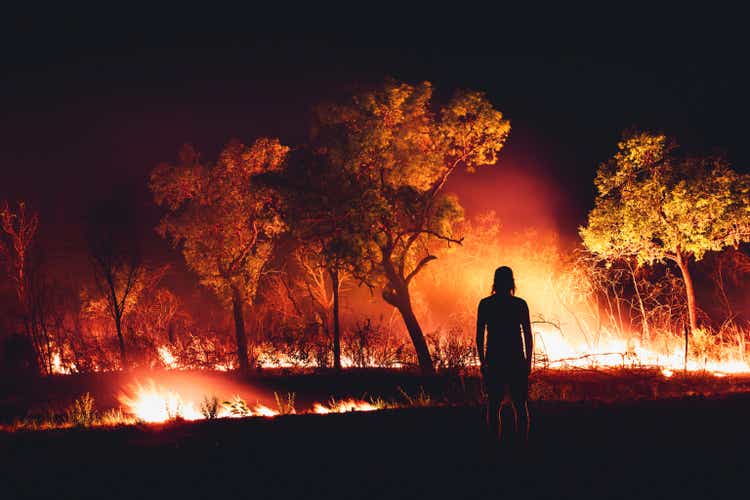 One person standing next to a wildfire photographed at night, The Kimberley, Western Australia, Australia