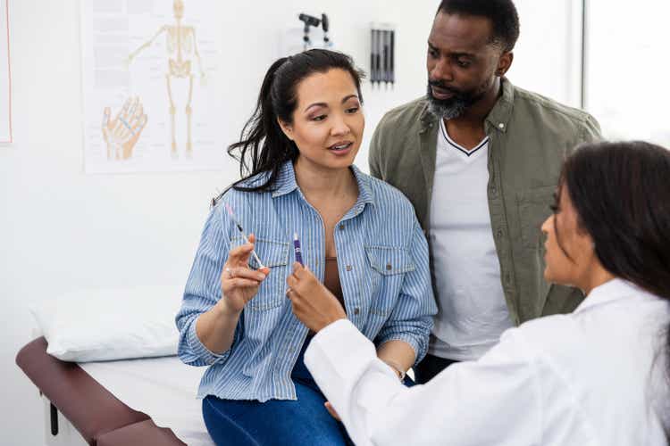 Husband watches as doctor answers wife"s question about IVF injection