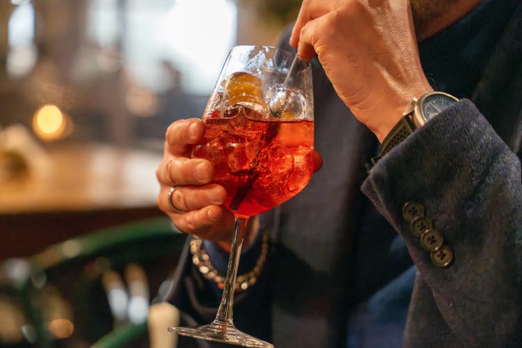A man is drinking a glass of red wine