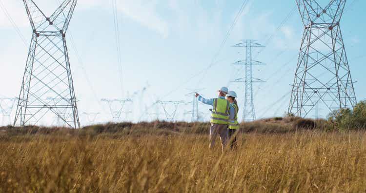 Teamwork, electrical engineer and inspection in power station with people for electricity transmission and tower check. Engineering, back and collaboration for energy distribution or mockup in field