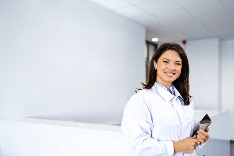 Portrait of female scientist in anti-static protection suit standing in research laboratory.