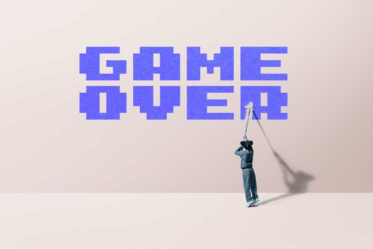 Girl painting "game over" text on wall