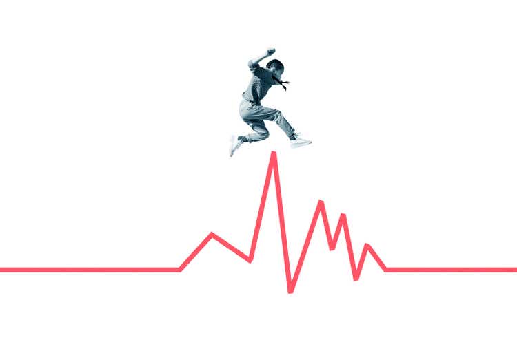 Girl jumping over red line graph